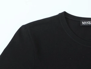Détail du col rond et des coutures d'épaule sur un t-shirt noir à manches longues