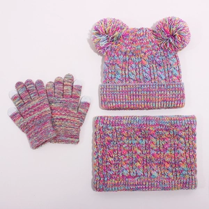 Close-up of winter knit set featuring double pom-poms, touch gloves, and cozy neck warmer