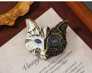 Close-up of vintage cat brooch with black and white enamel and blue rhinestone eyes