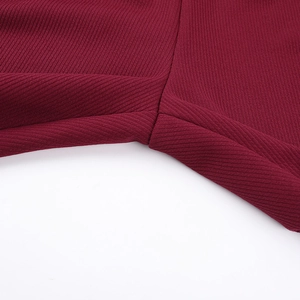 Dettaglio del tessuto a costine rosso scuro con cuciture precise e trama tessile