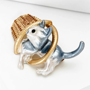 Detail of cute enamel cat in a golden basket brooch for cardigans and sweaters