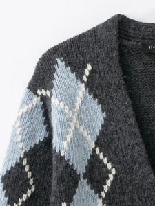 Close-up of thick grey argyle knit cardigan with blue and white diamond patterns
