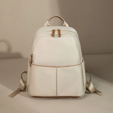 Close-up of cream leather mini bag featuring brown leather trim and chain detail