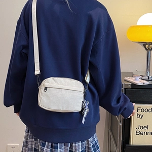 Waterproof nylon crossbody bag in cream color with shoulder strap for casual daily use