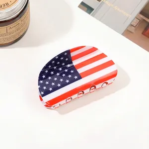 Detail of large hair claw clip featuring a glossy American flag star and stripes design