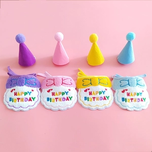 Detailed view of colorful knit pet birthday bibs and hats for small dogs and cats