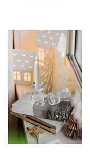 Close-up of vintage ribbed glass candle holders on a decorative book stack