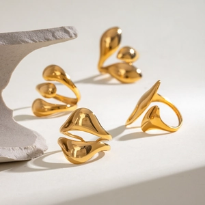 Minimalist gold stainless steel irregular water drop rings displayed on stone props