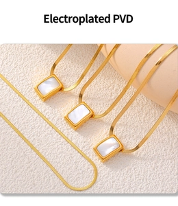 Macro detail of square mother of pearl pendant on a PVD gold plated herringbone chain
