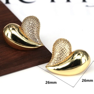 Detailed macro view of 26mm gold heart earrings with white cubic zirconia pavé setting