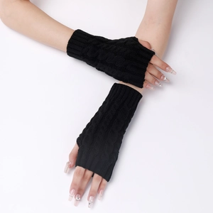 Close-up of black cable knit fingerless gloves showing the textured weave and warmth