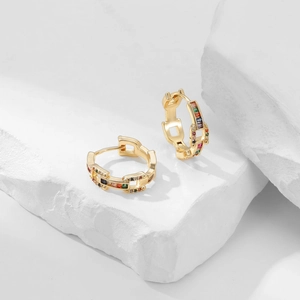 Minimalist gold plated zircon hoop earrings with colorful gemstones on marble background