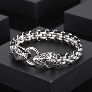 Men's stainless steel snake head bracelet with black braided leather on dark display