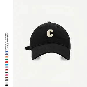 Detail of white 3D embroidered C letter on black cotton baseball cap with fabric texture