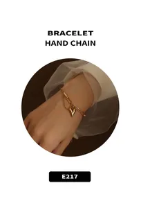 Detail of double-layer gold chain bracelet featuring a solid heart pendant on a model