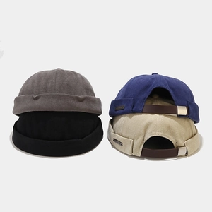 Détail de bonnets docker avec lanières en cuir et boucles métalliques argentées