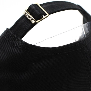 Detail of adjustable bronze metal buckle on black cotton camouflage baseball cap back
