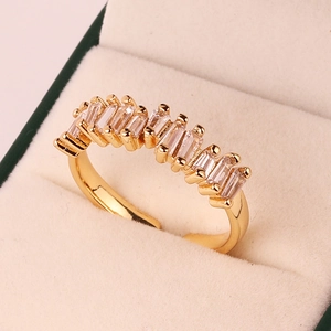 Macro shot of gold adjustable ring featuring nine rectangular clear gemstones in claw setting