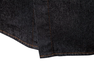 Detailed close-up of dark blue denim shirt with high-density orange contrast stitching