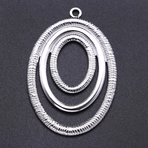 Macro shot of silver concentric oval pendants with textured and smooth finishes