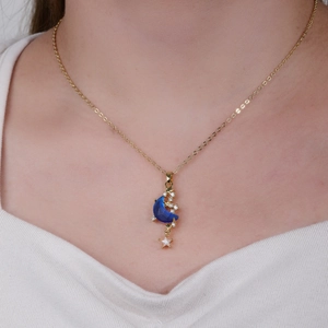 Gold-plated moon pendant necklace with blue resin and zircon star charms on model
