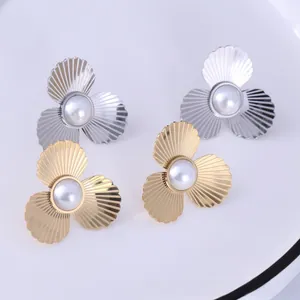 Detailed macro view of gold and silver floral pearl earrings with textured petals