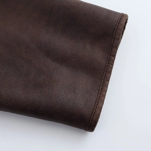 Close-up of deep brown faux leather jacket texture and neat edge stitching details