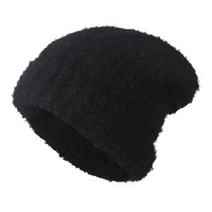 Close-up of thick black faux lamb wool beanie showing curly texture and warm knit detail