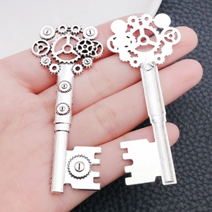 Macro detail of silver steampunk key pendant with mechanical gear design in palm