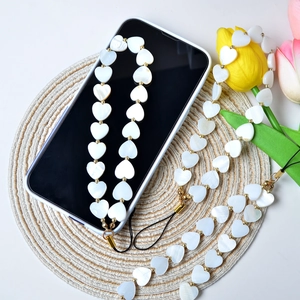 Detailed close-up of heart-shaped pearlescent beads with gold spacers on phone charm