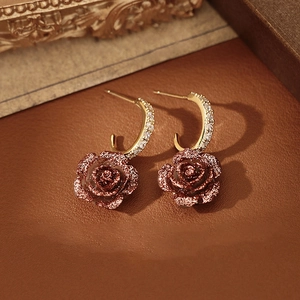 Boucles d'oreilles dorées en C avec pendentifs roses en résine et zircons brillants