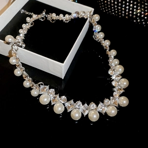 Macro detail of diamond-studded pearl necklace with geometric crystals on black surface