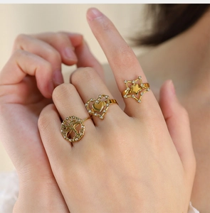 Detailed view of three gold-plated tree of life, heart, and star zircon stackable rings