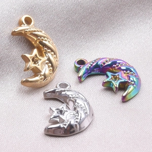 Macro shot of 18k gold, silver, and rainbow celestial moon and star pendants