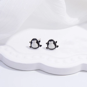 Close-up of cute S925 silver penguin stud earrings with black and white enamel finish