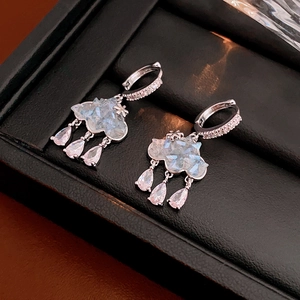 Détail de boucles d'oreilles nuage en argent avec pierres bleues et gouttes de zircon