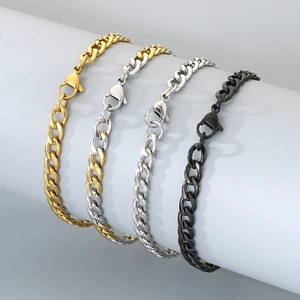Classic Cuban link bracelets in gold, silver, and black finishes on a grey display