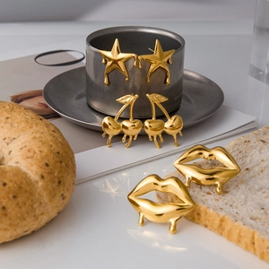 Detailansicht der 18K vergoldeten Edelstahlohrringe in Stern-, Kirsch- und Lippenform-Design