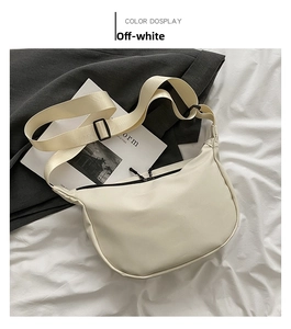 Detailed view of the beige crescent moon bag with wide adjustable shoulder strap