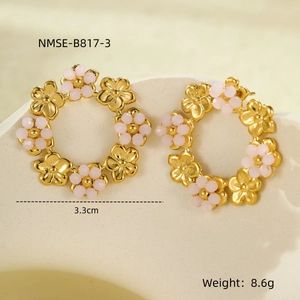 Macro shot of 3.3cm gold floral hoop earrings with light pink beads on stone background