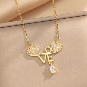 Golden heart necklace with LOVE letter pendant and zircon accents on beige fabric