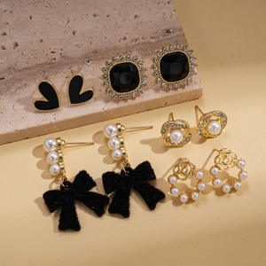 Detail of 5-pair earring set featuring black velvet bows, pearls, and golden metal finishes