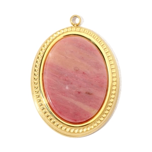 Détail d'un pendentif en pierre naturelle rose avec cadre en métal doré ciselé