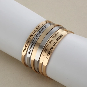 Detailansicht der Edelstahl-Armreifen mit 'I CAN DO ALL THINGS' Gravur in Gold und Silberfarben