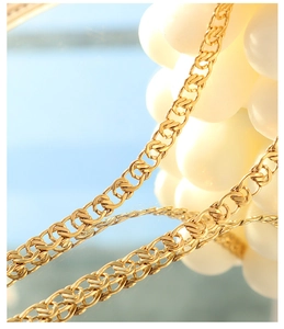 Detailed close-up of 18k gold interlocking chain links for necklace and bracelet set