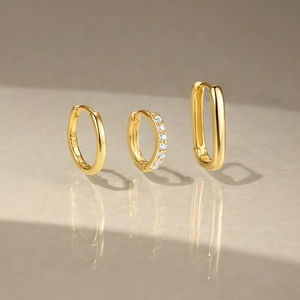 Detailed view of three assorted S925 sterling silver gold-plated hoop earrings with zircons
