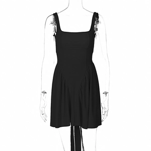 Detail view of black backless mini dress with ruffle trim and long tie-back ribbons