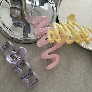 Set of 3 colorful wavy hair claws in pink yellow and purple on a neutral background