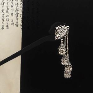 Vintage Chinese lotus hair pin with metallic bell tassels over a calligraphy scroll