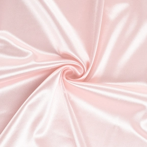 Close-up of pink satin fabric with elegant spiral folds and smooth silky texture